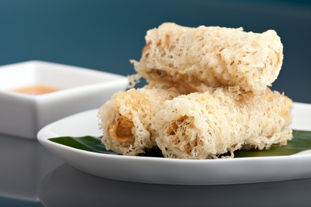Plate of crispy taro root crusted Thai spring rolls appetizer with sweet and savory dipping sauce.の写真素材
