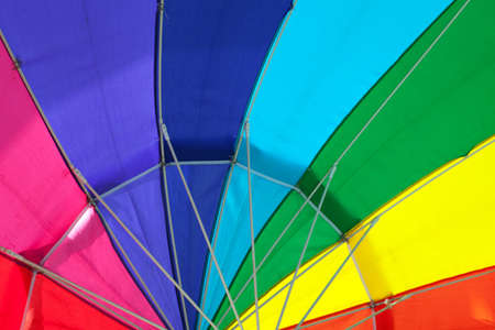 Close up of the interior of a rainbow colored rain umbrella.の写真素材