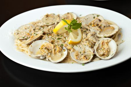 Italian pasta dish with fresh clams over pasta with herbs and cheese.  Shallow depth of field.の写真素材