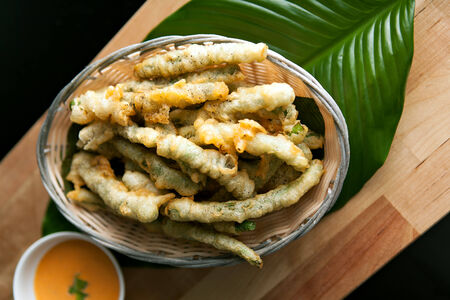 Thai style appetizer of fried tempura asparagus with dipping sauce. の写真素材