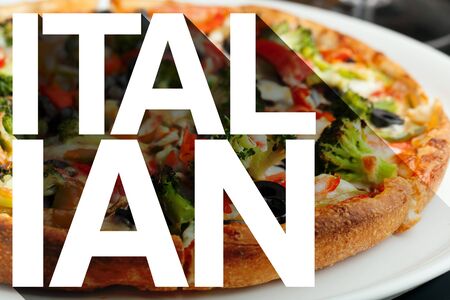 The word Italian with long shadow effect in front of a pizza with a variety of toppings.の写真素材