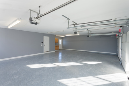 Beautiful brand new three car garage interior with finished floors and work space.の写真素材
