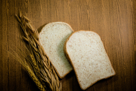 sliced grain bread on wood texture backgroundの写真素材