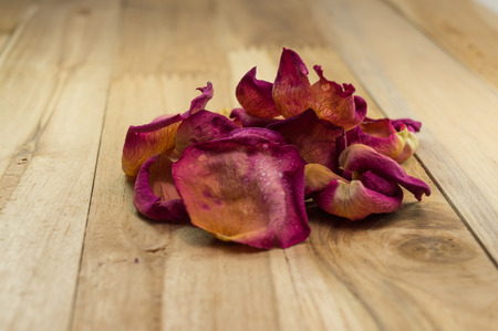 dried rose petals on wood groundの写真素材