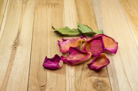 dried rose petals on wood groundの写真素材
