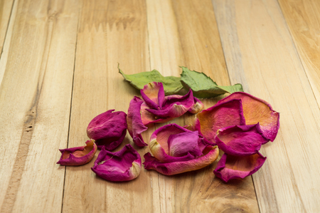 dried rose petals on wood groundの写真素材