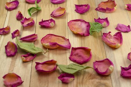dried rose petals on wood groundの写真素材