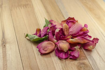 dried rose petals on wood groundの写真素材