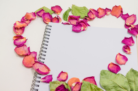 Black notepad. Love concept Realistic template notebook. Blank cover design. with dried rose petals and leaf. on cardboard background.の写真素材