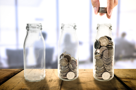Business investment growth Beautiful concept collecting coins in glass bottle on wood planks floor, Saving money concept.の写真素材