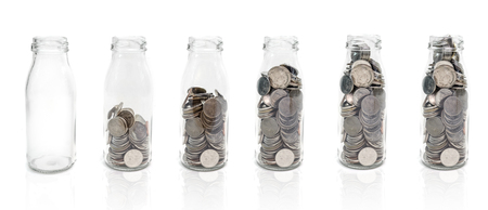 Saving money concept of collecting coins in glass bottle  from empty to full.Isolated on white background.の写真素材