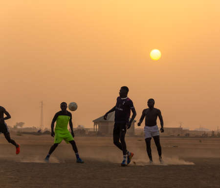 Boys and children playing football at sunset on a dusty pitch in Maroua, the capital city of the Far North Region of Cameroonのeditorial素材
