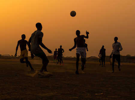 Boys and children playing football at sunset on a dusty pitch in Maroua, the capital city of the Far North Region of Cameroonのeditorial素材