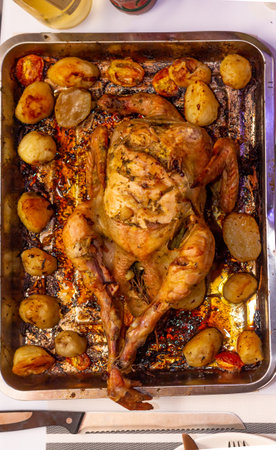 Oven roasted chicken served with potatoes for dinner.の写真素材