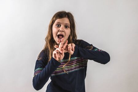 Girl doing hashtag sign on white background with blue t-shirt and laughingの写真素材