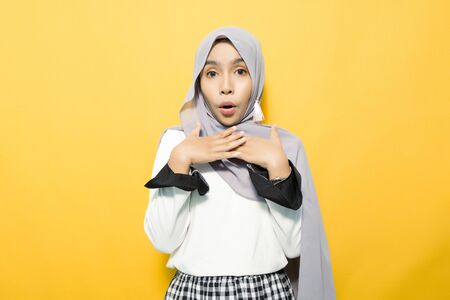 Excited asian woman with open mouth wearing hijabの写真素材