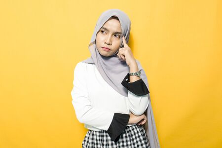 Portrait of young Asian woman thinking about wearing hijabの写真素材