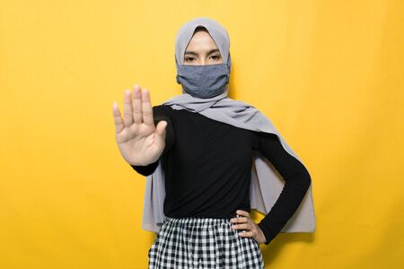 Asian woman wearing mask and making stop signの写真素材