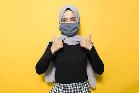 Asian woman wearing mask with satisfied signの写真素材