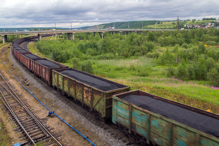 Railway train with coal follows the routeの写真素材