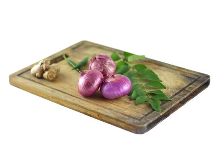 Fresh ingredients for cooking with onions, ginger and curry leaves.