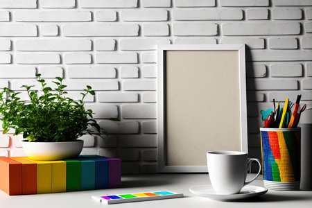 Creative workspace with a brick wall, a white table with a coffee cup and utensils, and colorful sticky notesの素材