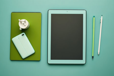 Work place at home with the tablet. Minimalism style top view. Green backgroundの素材