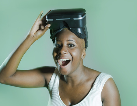 young attractive and happy black afro american woman showing VR 3d vision goggles after enjoying...