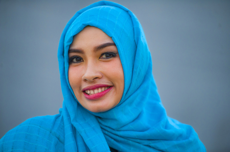 lifestyle isolated background portrait of young beautiful and happy Asian woman in hijab muslim head...