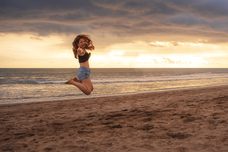 lifestyle outdoors portrait of young happy and beautiful Asian Korean woman jumping crazy excited on...