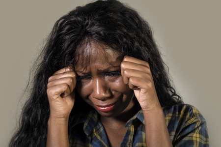 young sad and depressed black African American woman crying anxious and overwhelmed feeling sick and...