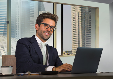 young happy and attractive successful businessman working at modern office in central business...