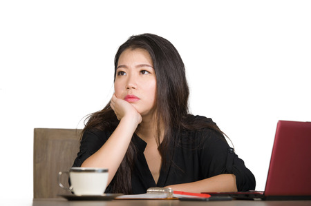 young beautiful sad and depressed Asian Chinese business woman working upset in stress at office computer desk feeling overwhelmed and frustrated suffering depression and anxietyの写真素材