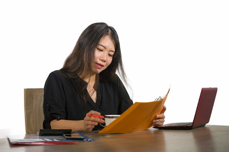 young beautiful and happy successful Asian Korean businesswoman working relaxed at office computer desk smiling confident doing paperwork in business success and entrepreneur woman lifestyleの写真素材