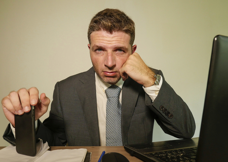 young desperate and depressed business man suffering problem and depression at office desk working...