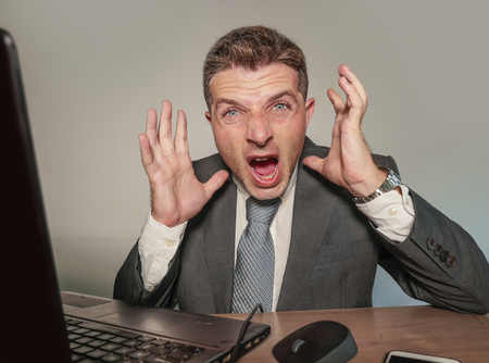 young stressed and overwhelmed businessman in suit and tie working at office laptop computer desk...