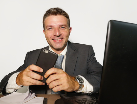 young attractive and happy businessman in suit and necktie working on office laptop computer desk...