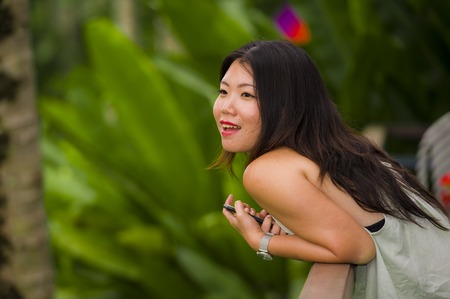 lifestyle outdoors portrait of young beautiful and happy Asian Chinese woman enjoying holidays at tropical rice terrace smiling delighted in Asia travel destination conceptの写真素材