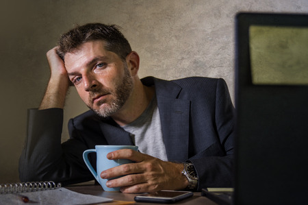 young attractive depressed and frustrated man working at office computer desk desperate and...