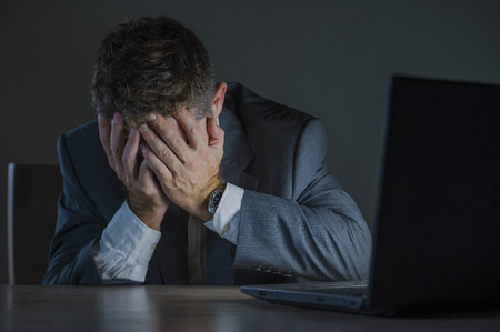 young desperate and stressed businessman working overtime at office laptop computer desk feeling...