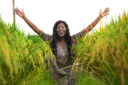 outdoors fresh portrait of young beautiful and happy black afro American woman in cool dress having fun at tropical rice field enjoying exotic holidays trip in Asia exploring traditional villageの写真素材