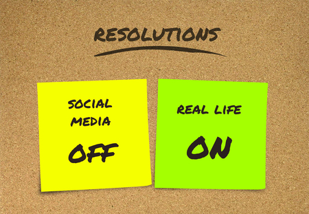 list of handwritten New Years resolutions and goals sticky notes : social media off and real life on in commitment determination and positive thinking concept isolated on cork board backgroundの写真素材