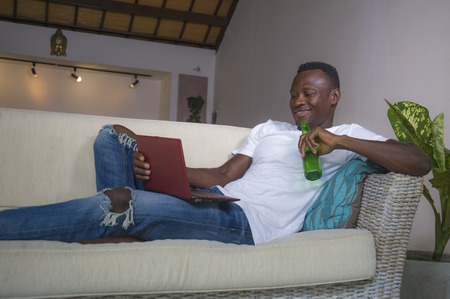 young attractive and happy successful black African American man networking with laptop computer at...