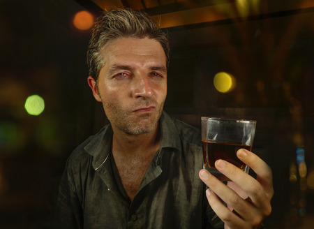 young messy and wasted man drunk at night club or bar drinking whiskey glass looking hammered...