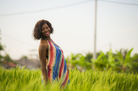lifestyle portrait of young attractive and happy black African American woman posing cheerful having fun outdoors at beautiful rice field background enjoying holidays trip in nature and tourism conceptの写真素材