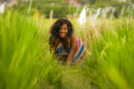 lifestyle portrait of young attractive and happy black African American woman posing cheerful having fun outdoors at beautiful rice field background enjoying holidays trip in nature and tourism conceptの写真素材