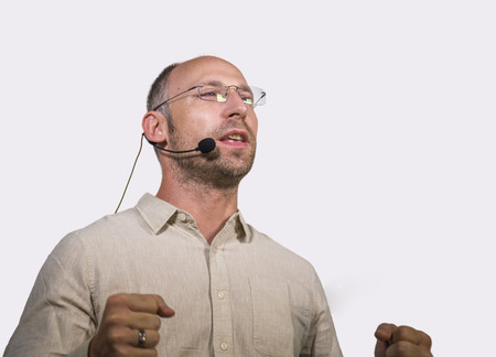 young successful and confident casual speaker man with headset speaking at corporate business...