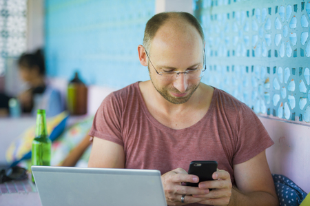 lifestyle portrait of young happy and confident backpacker man working with laptop computer and...