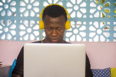 young cool and hipster black afro American business man networking with laptop computer and...