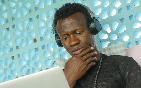 young attractive and hipster black African American business man working with laptop computer and...